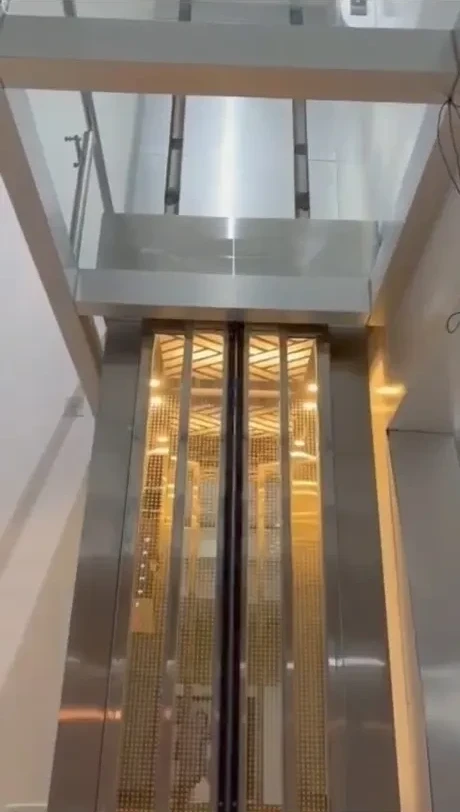 Custom round glass villa elevator cabin matched to a staircase shaft