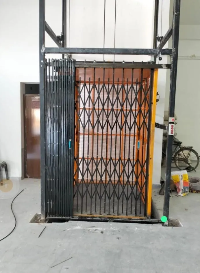 Industrial elevator cabin with collapsible gate needing mechanical attention